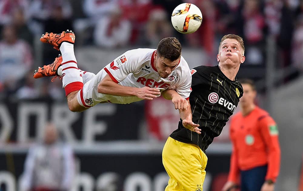 Colognes Jonas Hector, left, jumps for the ball against Dortmunds Matthias Ginter during the German Bundesliga soccer match between 1.FC Cologne and Borussia Dortmund in Cologne, Germany.