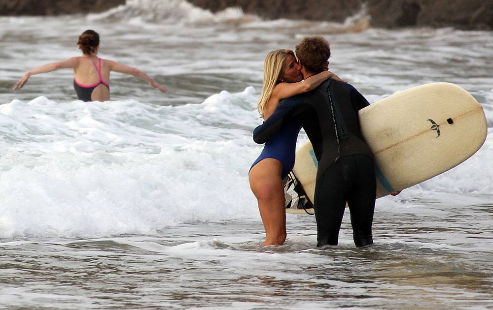 A couple kiss on the beach of Biarritz, southwestern France.