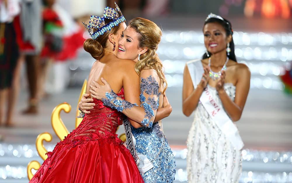 Miss World contestant Mireia Lalaguna Royo from Spain, centre, is hugged by reigning Miss World Rolene Strauss of South Africa before being crowned at the end of the 2015 Miss World Grand Final in Sanya in south China's Hainan province.