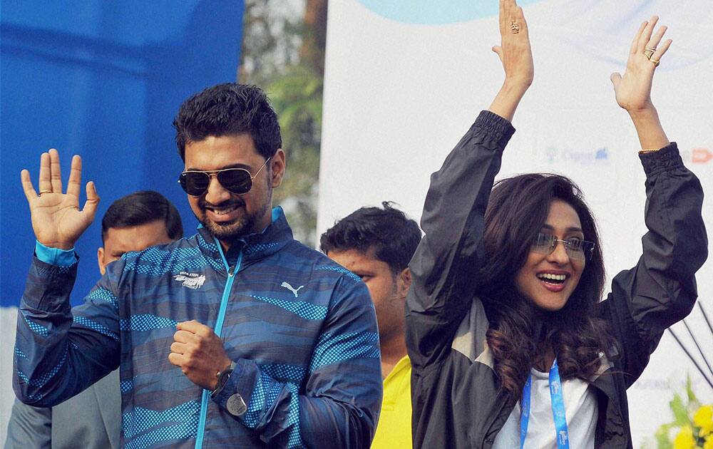 Actor and Trinamool Congress MP Dev with actress Rituparna Sengupta gesture to the participants of Tata Steel Kolkata 25k run, at Red Road in Kolkata.