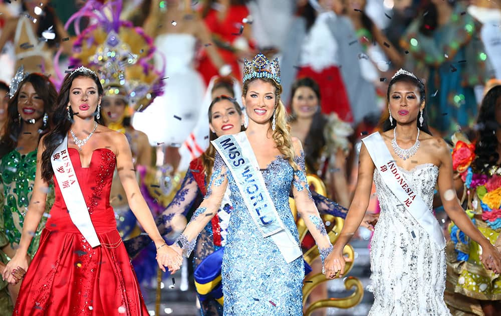 Miss World Mireia Lalaguna Royo from Spain, center, Sofia Nikitchuk from Russia, left, the runner-up, and Maria Harfanti from Indonesia, right, the second runner-up celebrate at the end of the 2015 Miss World Grand Final in Sanya in south China's Hainan province.