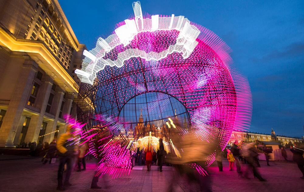 People walk at Manezhnaya Square illuminiated to celebrate the upcoming Christmas and New Year near Red Square in Moscow, Russia.