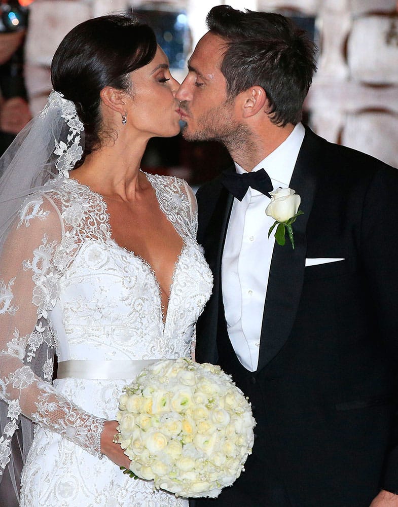 British TV personality Christine Bleakley, left, kisses British soccer player Frank Lampard as they leave after their wedding, at St Paul's Church, in Knightsbridge, London.