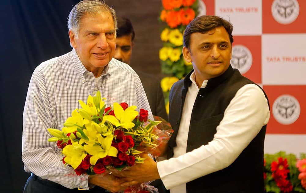 Uttar Pradesh Chief Minister Akhilesh Yadav, right, presents flowers to industrialist Ratan Tata during the signing of agreements between Tata Trusts and the Uttar Pradesh state government in Lucknow.