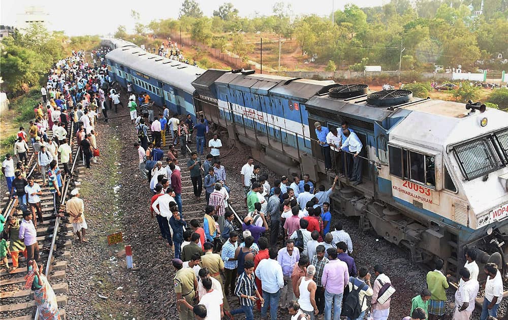 People gather near the site where engine and one coach of Puducherry-Dadar express train derailed at Unkal Station near Hubli, Karnataka.