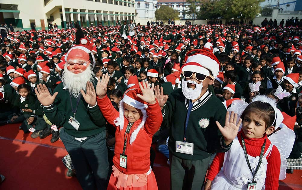 Children wear Santa Claus claps during Christmas celebrations at a school in Bhopal .