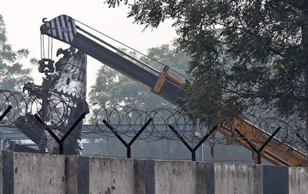 A crane is used to salvage the remains of a small Indian paramilitary plane that crashed outside the main airport in New Delhi, Dec 22, 2015. 