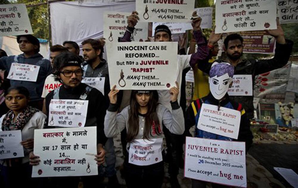 People hold placards as they protest the release of a juvenile convicted in the fatal 2012 gang-rape that shook the country.