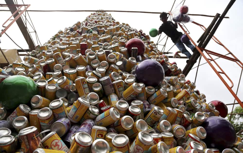 A worker arranges about ten thousand discarded beverage cans to form a Christmas tree in front of a church in Jakarta, Indonesia.