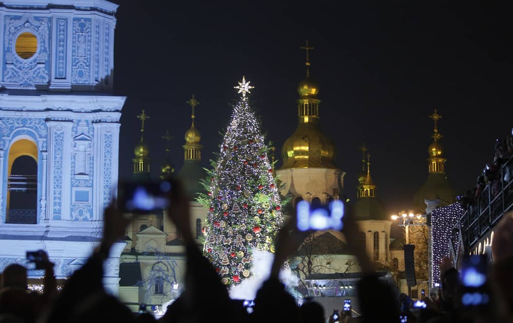 UKRAINIANS TAKE PICTURES OF THE CHRISTMAS TREE, DECORATED FOR CHRISTMAS AND NEW YEAR CELEBRATIONS NEAR TO ST. SOPHIA'S CATHEDRAL IN DOWNTOWN KIEV, UKRAINE.