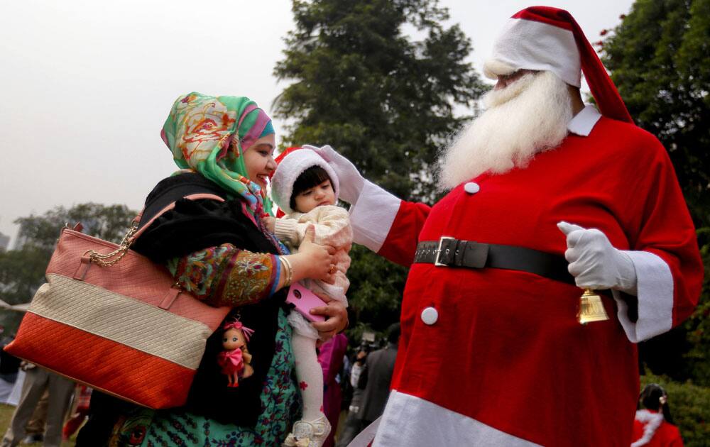 A man dressed as Santa Claus blesses a child at a Christmas party in Dhaka, Bangladesh.