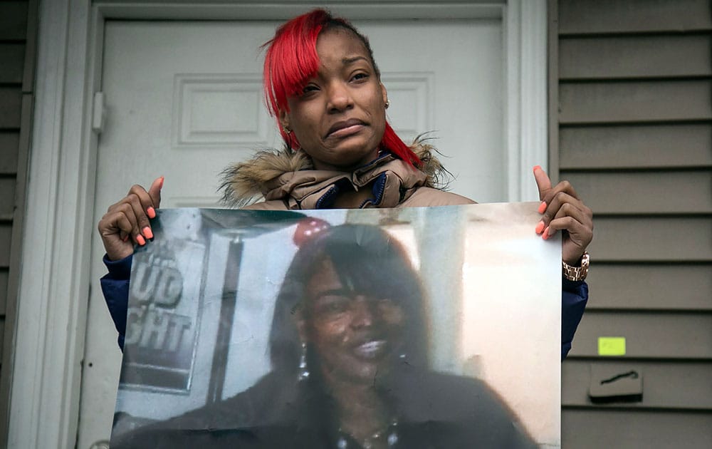 Latonya Jones, 19, holds a photo of her mother, Bettie Jones, during a vigil in Chicago. 