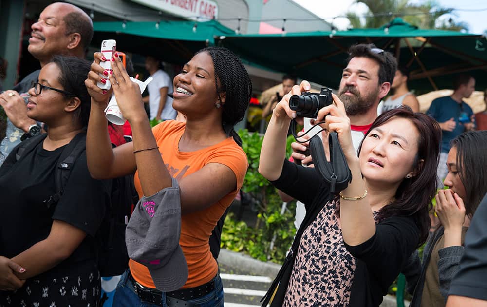 People take photos of President Barack Obama during a visit to Island Snow to get shave ice during a family vacation in Kailua, Hawaii.