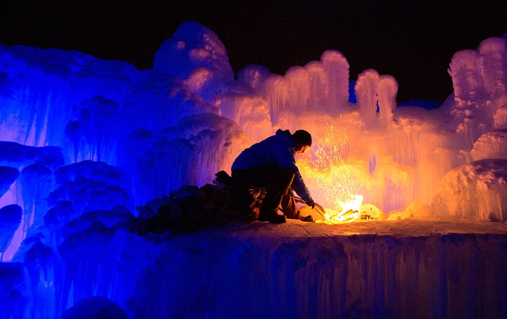 An employee stokes a fire in a giant ice castle in Edmonton, Alberta.