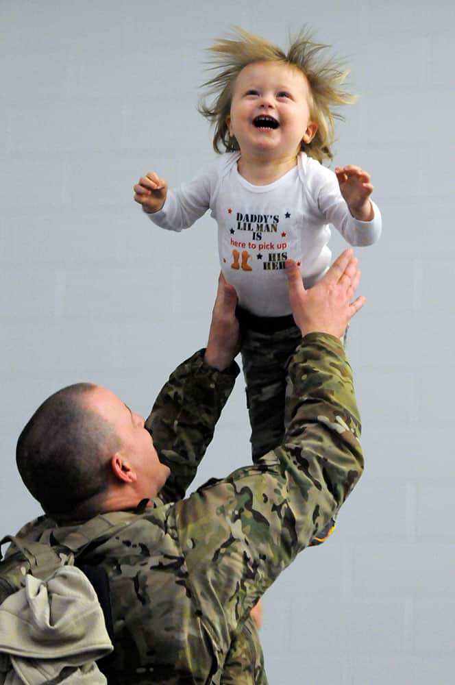 Sgt. First Class Gary Foran Jr. tosses his 18-month old son Logan into the air after arriving at the National Guard's Windsor Locks Army Aviation Readiness Center in Windsor Locks, Conn.