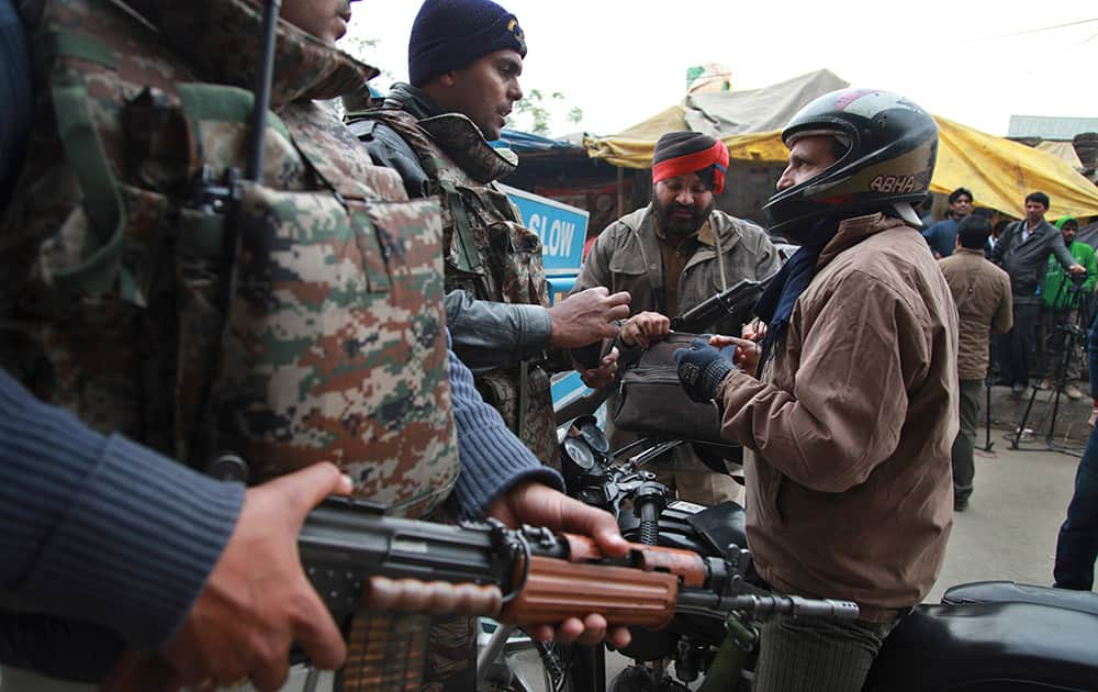 Indian security personnel check people entering an airbase in Pathankot.