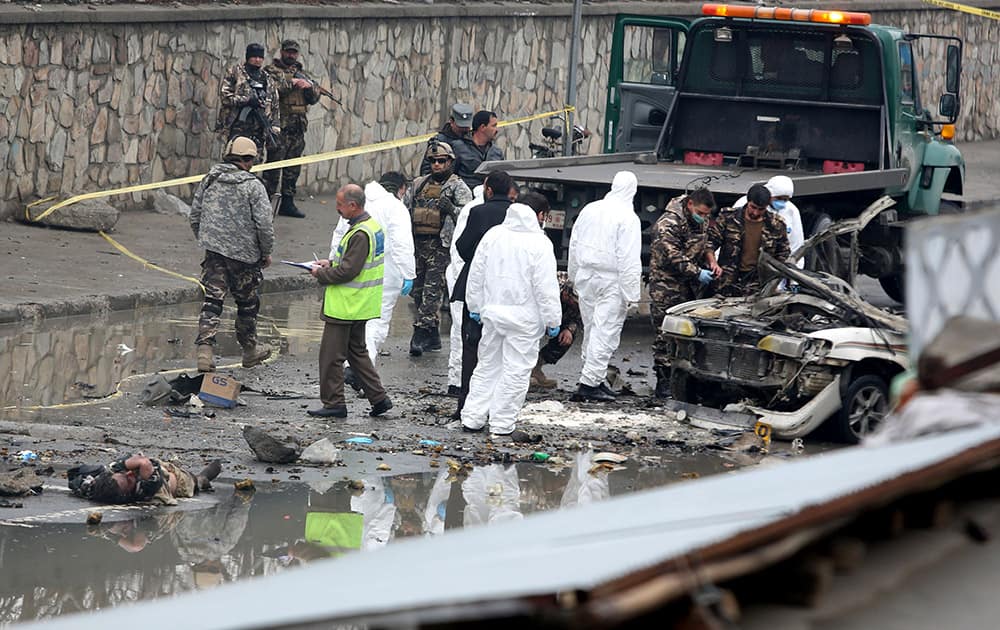 Afghan security forces inspect the site of a suicide attack near Kabul International Airport in Kabul, Afghanistan.