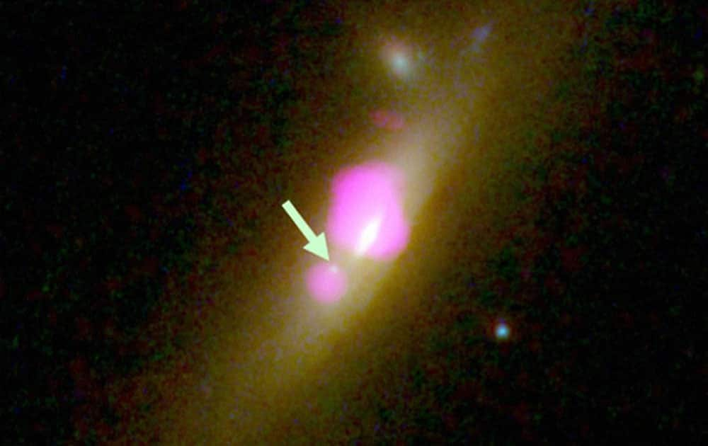 This image provided by CU-Boulder shows the galaxy SDSS J1126+2944 taken with the Hubble Space Telescope and the Chandra X-ray Observatory, with an arrow placed by the source pointing to a black hole that lost most of its stars. The University of Colorados Julie Comerford has discovered something even rarer than a double-black hole galaxy: a skinny black hole. Her findings were reported Tuesday, Jan 5, 2016 at the American Astronomical Societys annual meeting. 