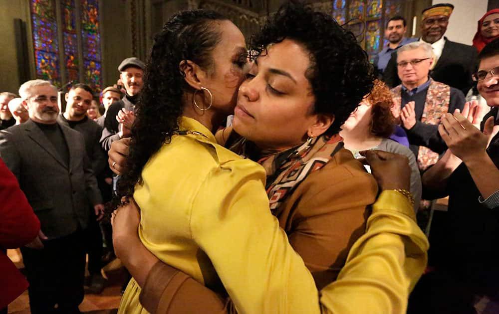 Wheaton College professor Larycia Hawkins, left, is hugged by former student Rachel Brooks after a news conference in Chicago.