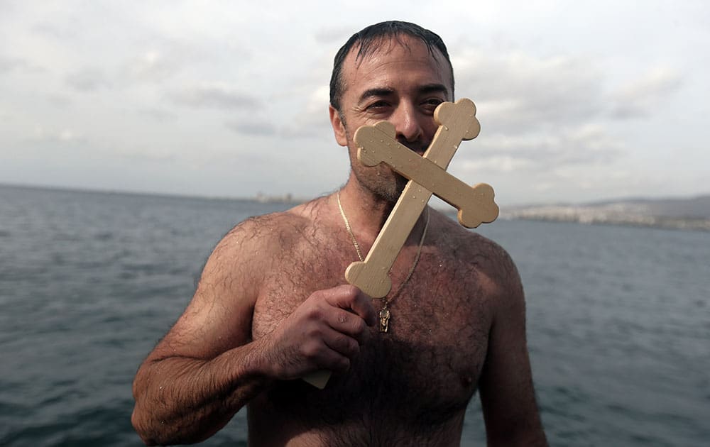 Lefteris Chrisomallos from Greece kisses a wooden cross after he retrieved it, during an Epiphany ceremony in Izmir, Turkey.