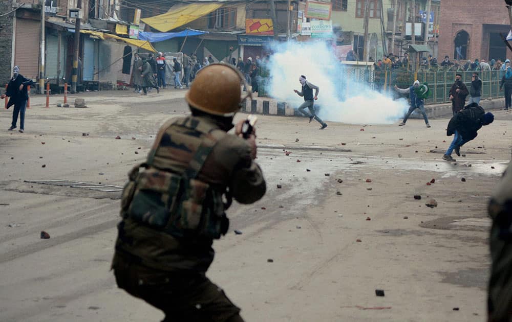 A Policeman fires tear gas shell to disperse stone throwing youth during clash between police and protesters at Nowhatta in Srinagar.