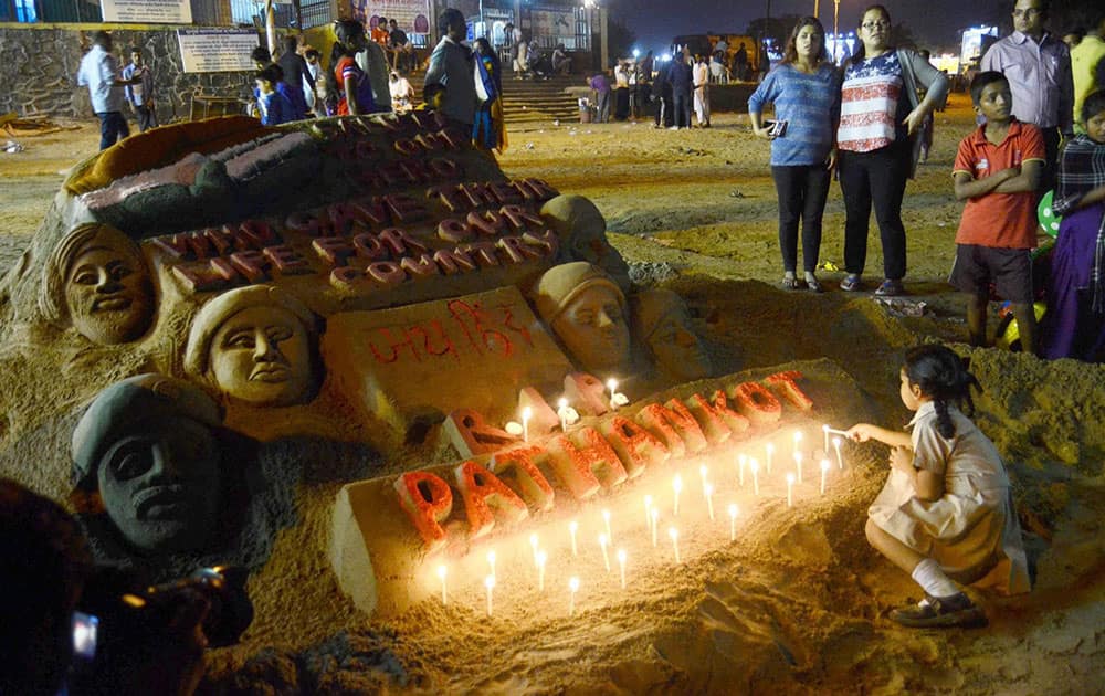 People admire a sand sculpture created to pay tributes to the martyrs who lost their lives in the Pathankot terrorist attack, at Juhu Chowpatty in Mumbai.
