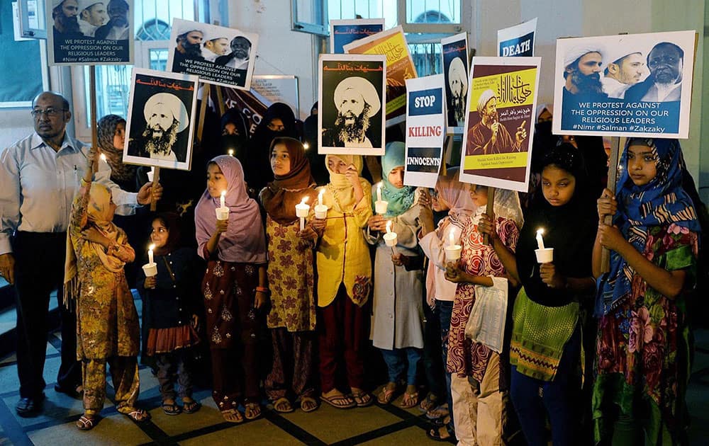 Shia Muslims hold candles and poster of Saudi Arabian Shia Cleric, Ayatullah Baqir al Nimr, who was executed in Saudi Arabia recently, during a candle light protest against The Saudi Rulers, in Bengaluru.