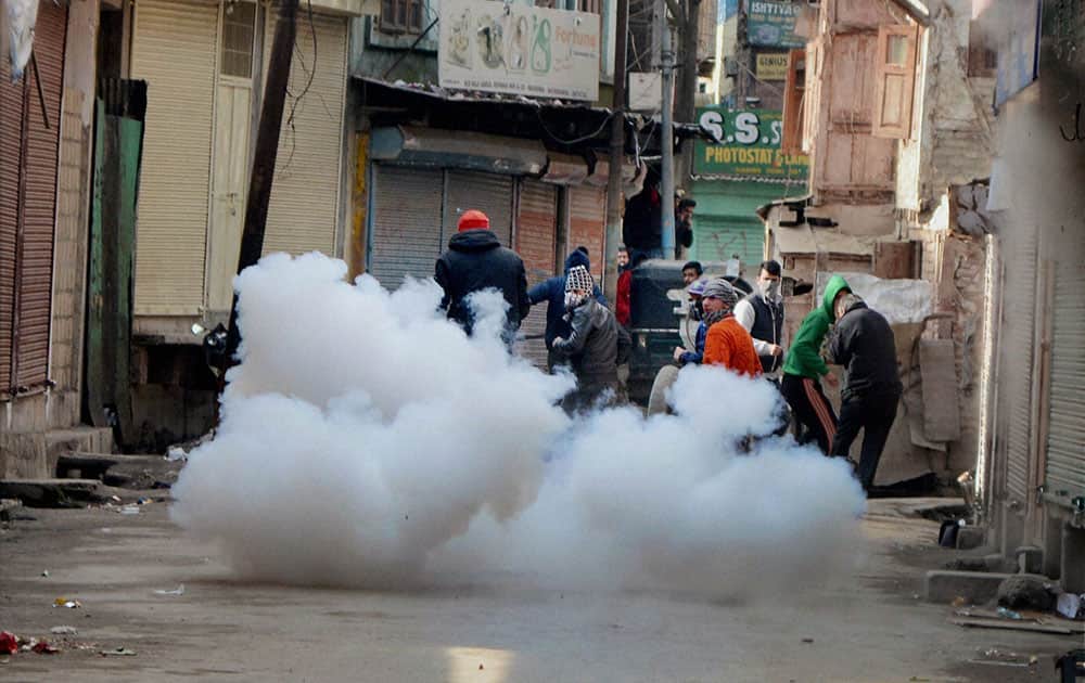 Stone throwing youths run for cover amid bursting tear gas shells fired by police to disperse them during clashes at Maisuma in Srinagar, which erupted after the arrest of JKLF Activist Ashiq Hussain. 