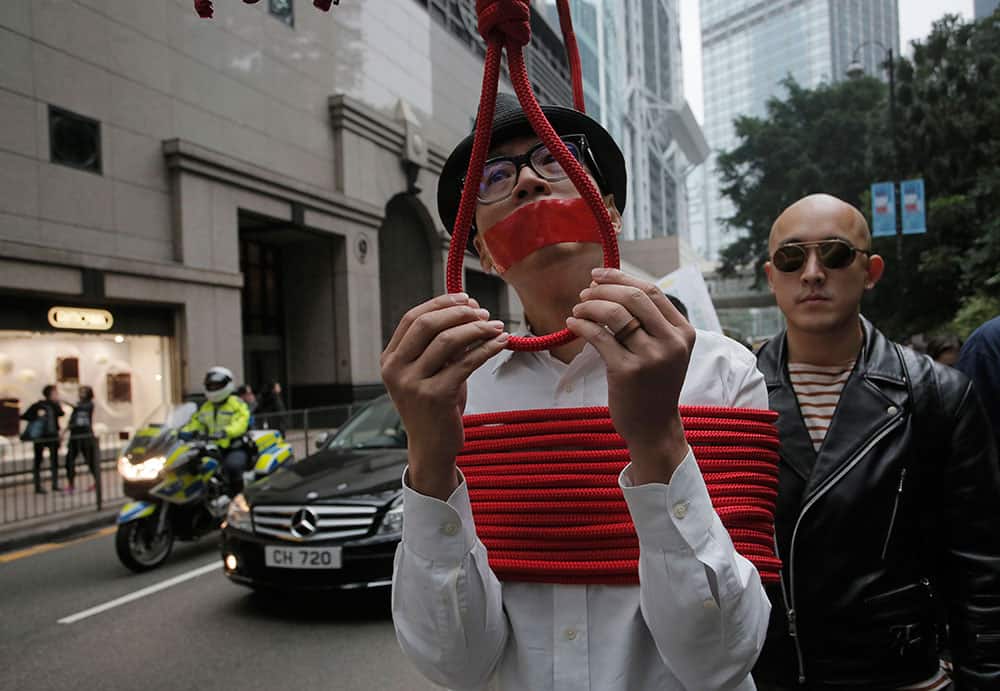 A local artist ties himself with a rope during a protest against the disappearances of booksellers in Hong Kong.