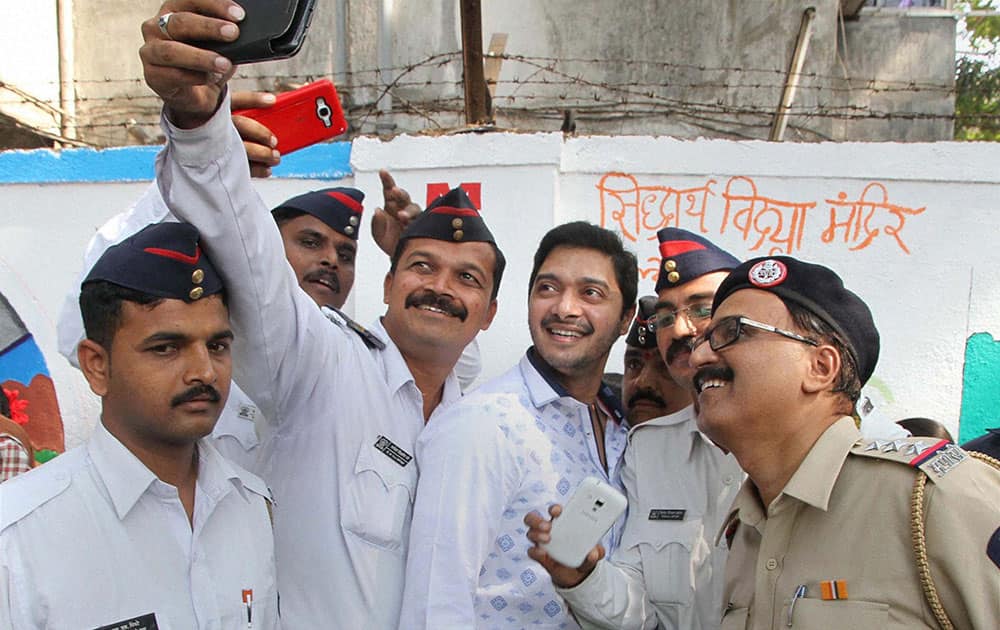 Bollywood actor Shreyas Talpade pose for a selfie with policemen as he takes part in a traffic awareness campaign during Road Safety Week in Thane, Mumbai.