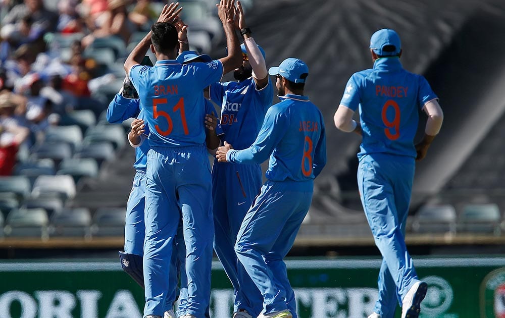 Barinder Sran is congratulated by teammates after taking a wicket during their one day international cricket match against Australia in Perth, Australia.