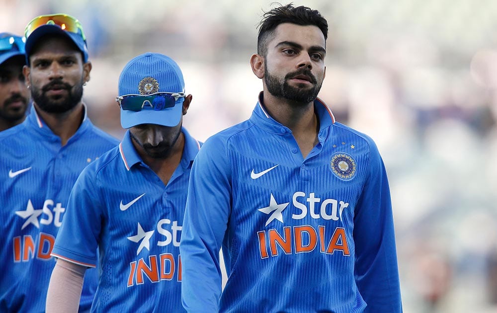 Virat Kohli walks off the ground with teammates after being defeated by Australia in their one day international cricket match in Perth, Australia.