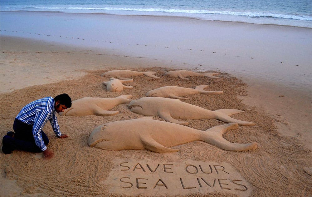 Sand artist Sudarsan Pattnaik makes a sand art with message save our sea lives at the Puri beach of Odisha after many whales died at beach in Tuticorin district of Tamil Nadu.