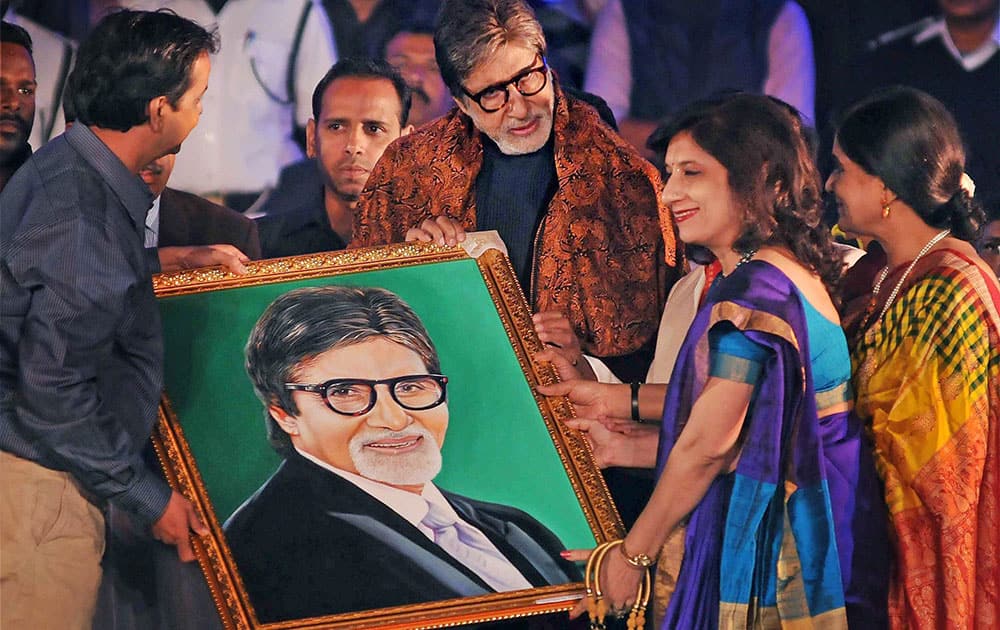 Fans present a portrait to Bollywood megastar Amitabh Bachchan during inauguration of a dance programme at historic Victoria Memorial in Kolkata.