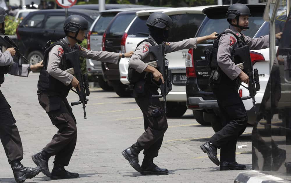 Police officers take their position near the site where an explosion went off in Jakarta.