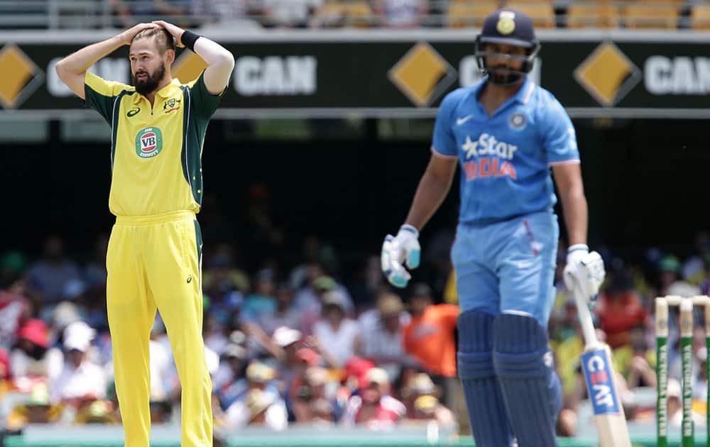Australia's Kane Richardson, left, reacts after India's Rohit Sharma, right, missed a shot during the 2nd One Day International cricket match between Australia and India in Brisbane, Australia.
