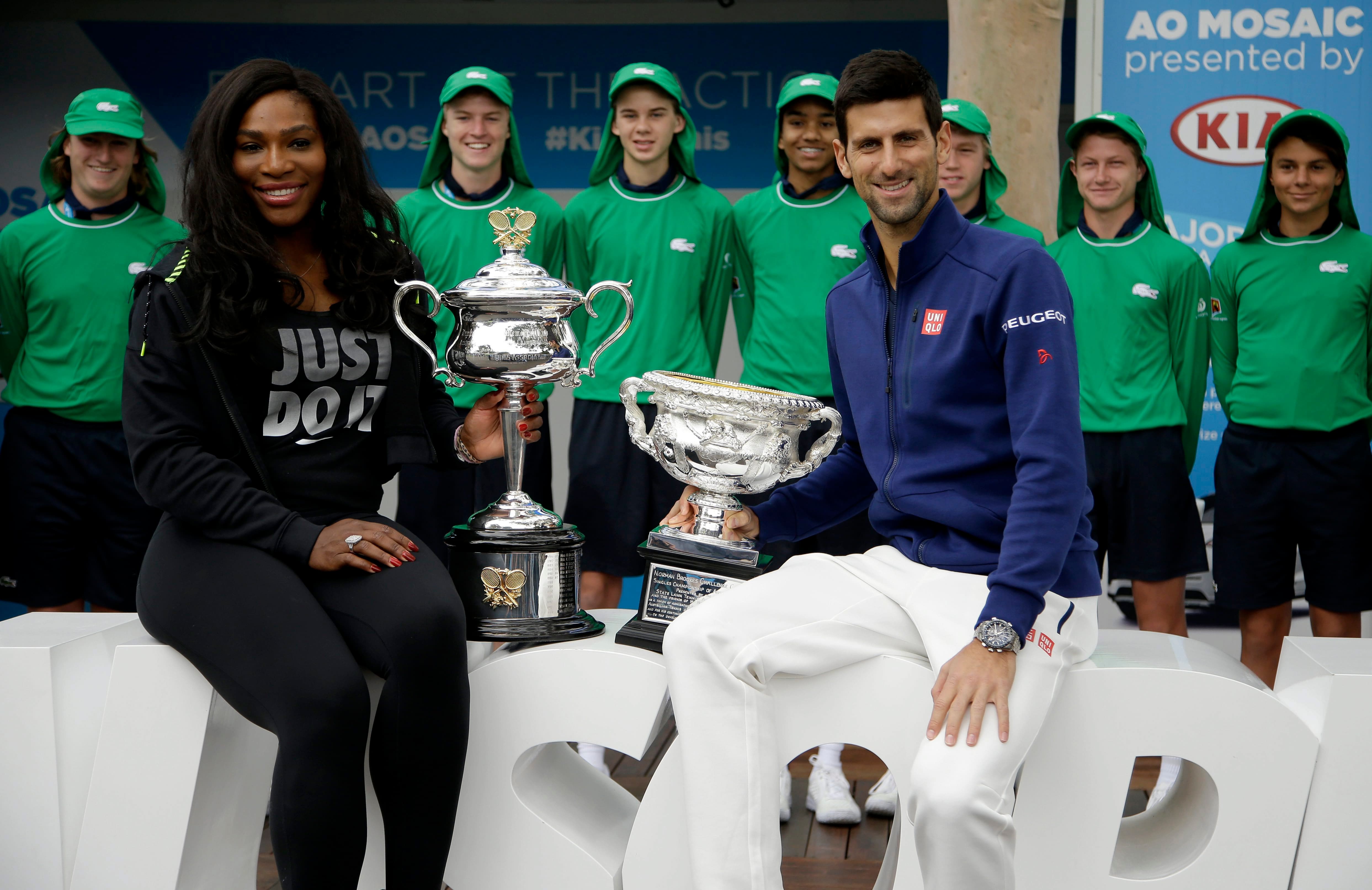 Defending champions Serena Williams of the US and Serbias Novak Djokovic pose for a photo with their trophies as they arrive for the official draw at the Australian Open tennis championships.