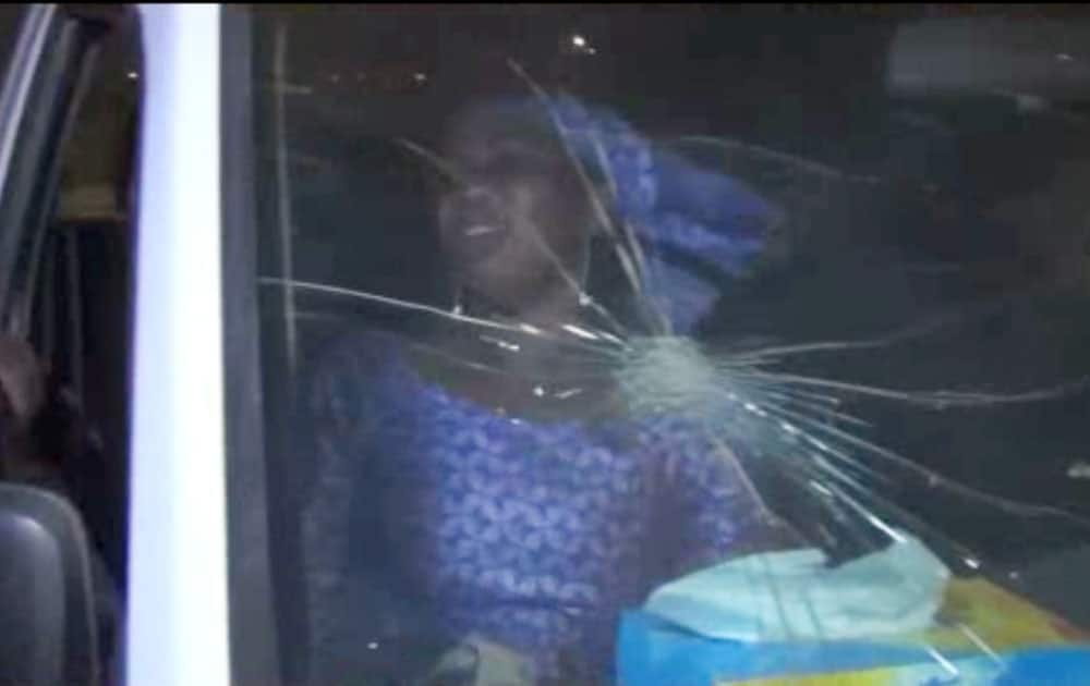 A RESCUED WOMAN SITS IN A VEHICLE WITH BULLET HOLE IN WINDSHIELD NEAR THE SPLENDID HOTEL IN BURKINA FASO.
