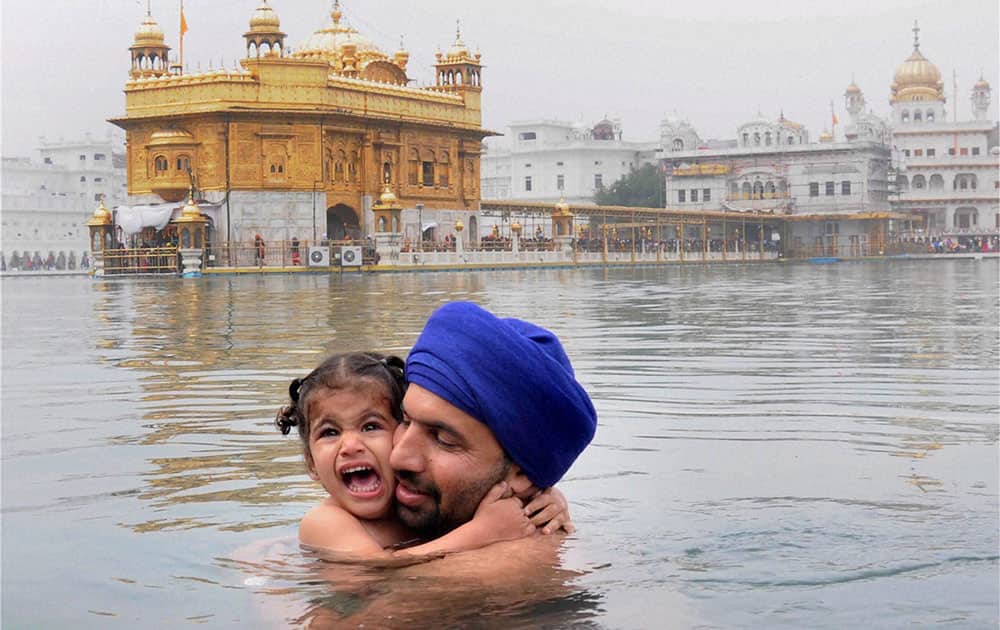 A devotee takes holy dip in Sarovar at Golden Temple on the occasion of birth anniversary of 10th Sikh Guru Gobind Singh.