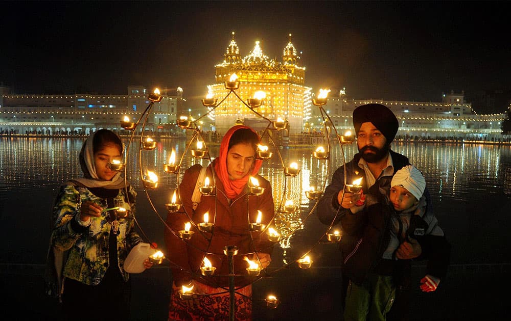 People lights candles at Golden Temple on the occasion of birth anniversary of 10th Sikh Guru Gobind Singh in Amritsar.