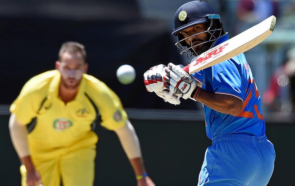 India's Shikhar Dhawan, right watches a ball bowled by Australia's John Hastings, left, during their one day international cricket match in Melbourne, Australia