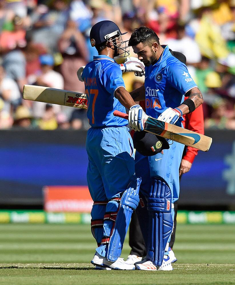 India's Virat Kohli, right, is congratulated by teammate Ajinkya Rahane after scoring a century against Australia during their one day international cricket match in Melbourne, Australia.