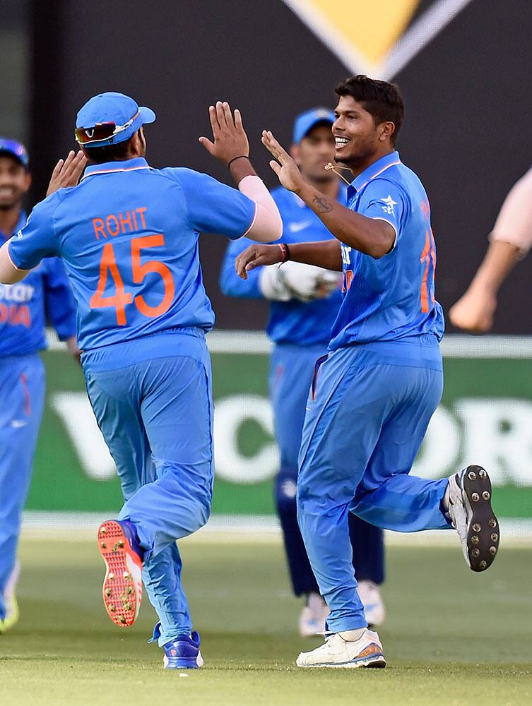 India's Umesh Yadav, right, celebrates with teammate Rohit Sharma, left, the wicket of Australia's Aaron Finch during their one day international cricket match in Melbourne, Australia.