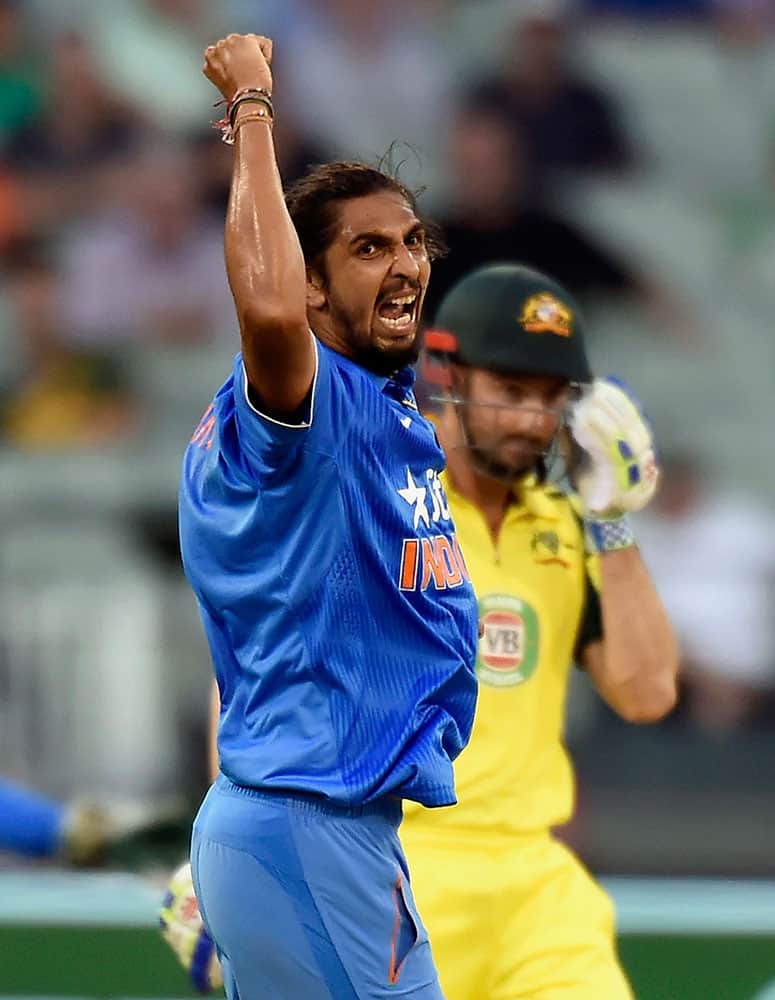 India's Ishant Sharma, left, celebrates capturing the wicket of Australia's Shaun Marsh, right, during their one day international cricket match in Melbourne, Australia.