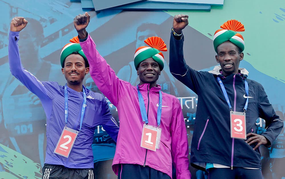 Winner Kenya’s Gideon Kipketer, center, poses with Ethipia’s Seboka Dibaba, left, who came in second and Kenya’s Marius Kimutai, right who finished third after the Mumbai marathon in Mumbai.