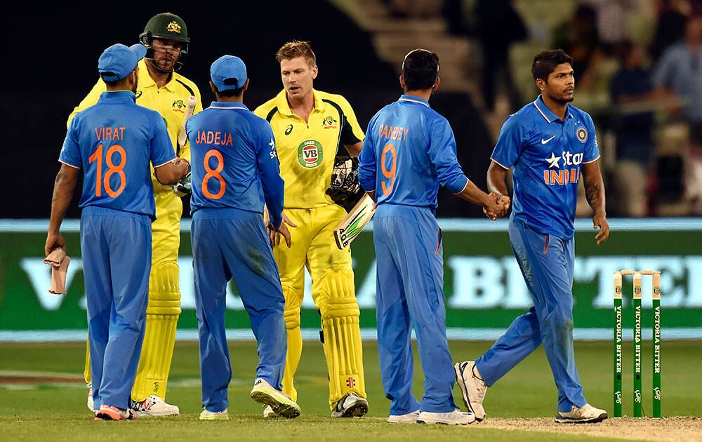 Australia's Josh Hazlewood, second left, and James Faulkner, center right, shake hands with Indian players after defeating them during their one day international cricket match in Melbourne, Australia.