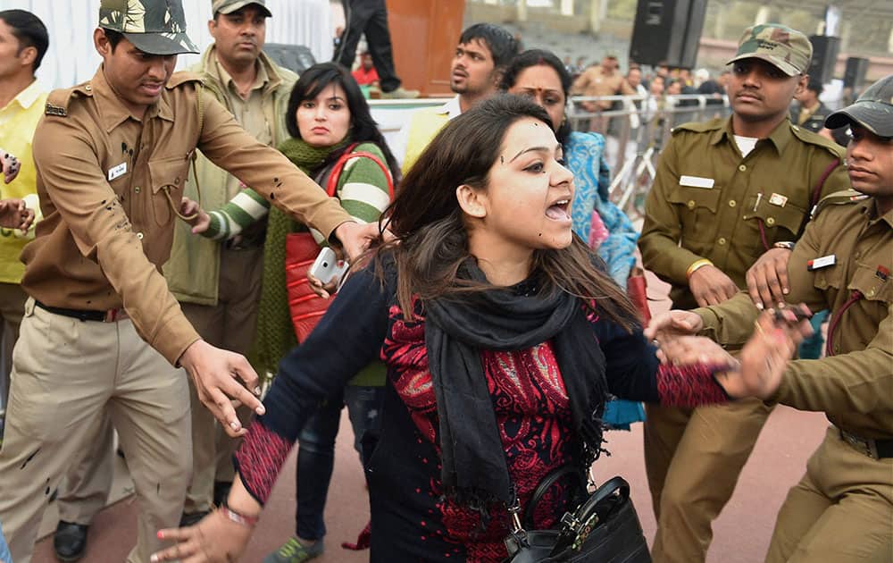 Policemen try to control a member of Aam Aadmi Sena after she splattered Delhi CM Arvind Kejriwal with ink while protesting against the CNG scam, at a thanksgiving rally following the “success” of his government’s odd-even scheme at Chhatrasal Stadium, in New Delhi.