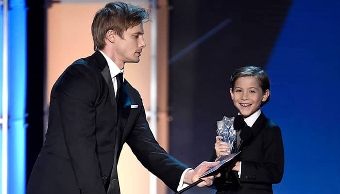 Bradley James, left, holds the microphone for Jacob Tremblay as he accepts the award for best young actor/actress for “Room” at the 21st annual Critics' Choice Awards at the Barker Hangar.