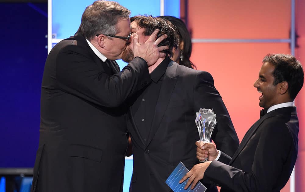 Adam McKay, left, kisses Christian Bale as he accepts the award for best comedy for “The Big Short” at the 21st annual Critics' Choice Awards.