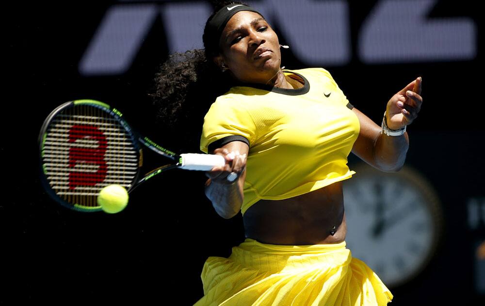 Serena Williams of the United States makes a forehand return to Camila Giorgi of Italy during their first round match at the Australian Open tennis championships in Melbourne, Australia, Monday, Jan. 18, 2016.